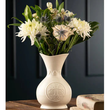 White vase with floral arrangement on a dark background