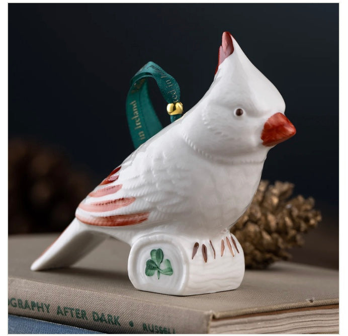 White cardinal ornament with red accents on a dark background