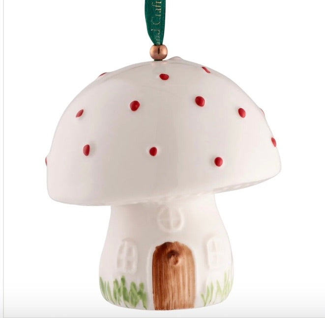 Mushroom-shaped ornament with a small door and red spots on a white background