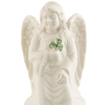 An off-white ceramic angel figurine with a green Shamrock accent on its chest, set against a plain white background.