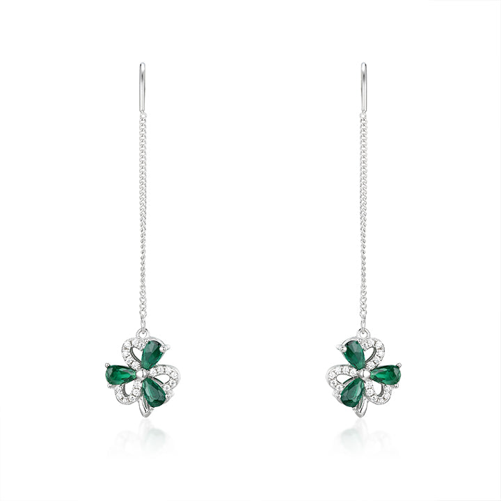 Pair of emerald earrings on a white background