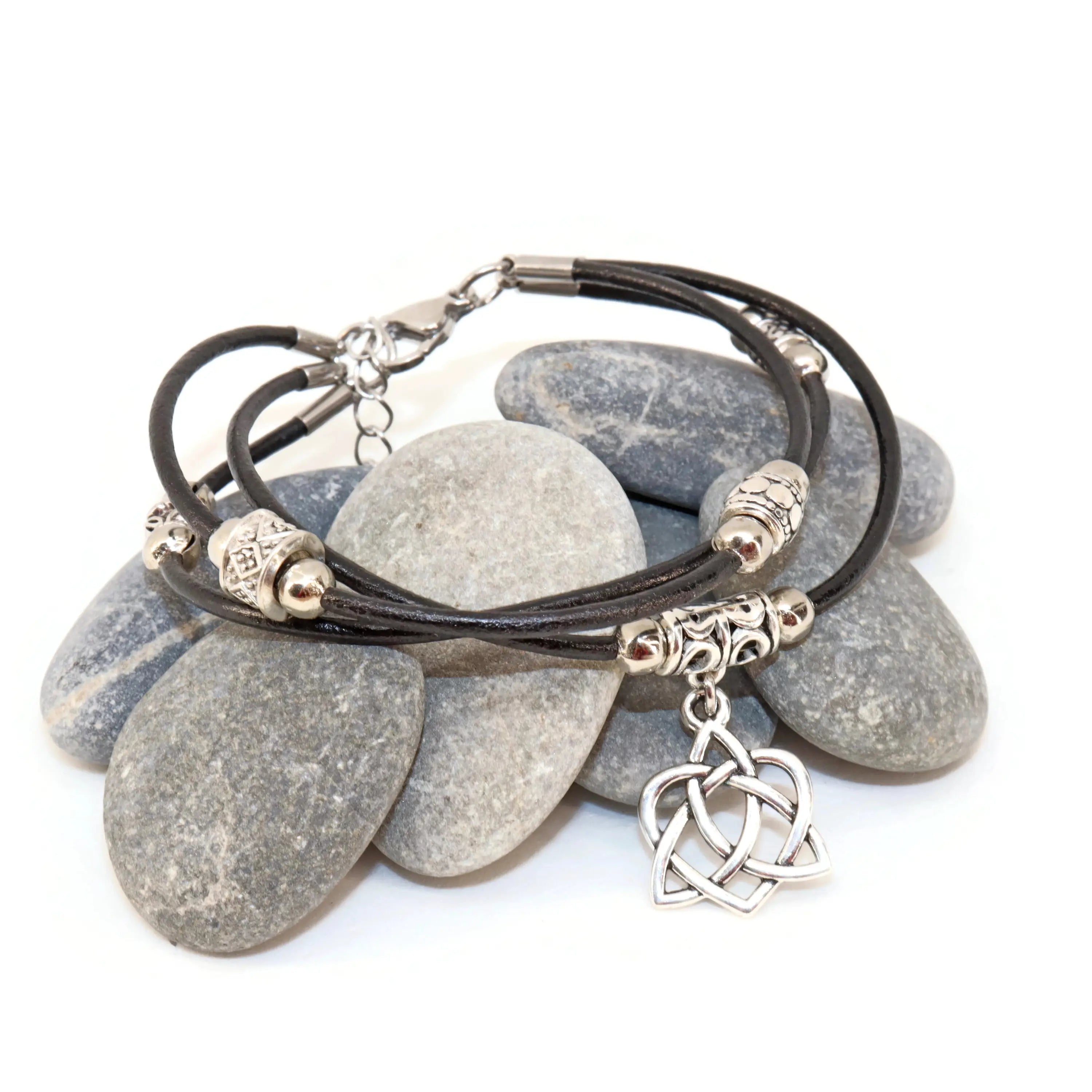 Bracelet with stone-like beads and Celtic knot charm on a white background