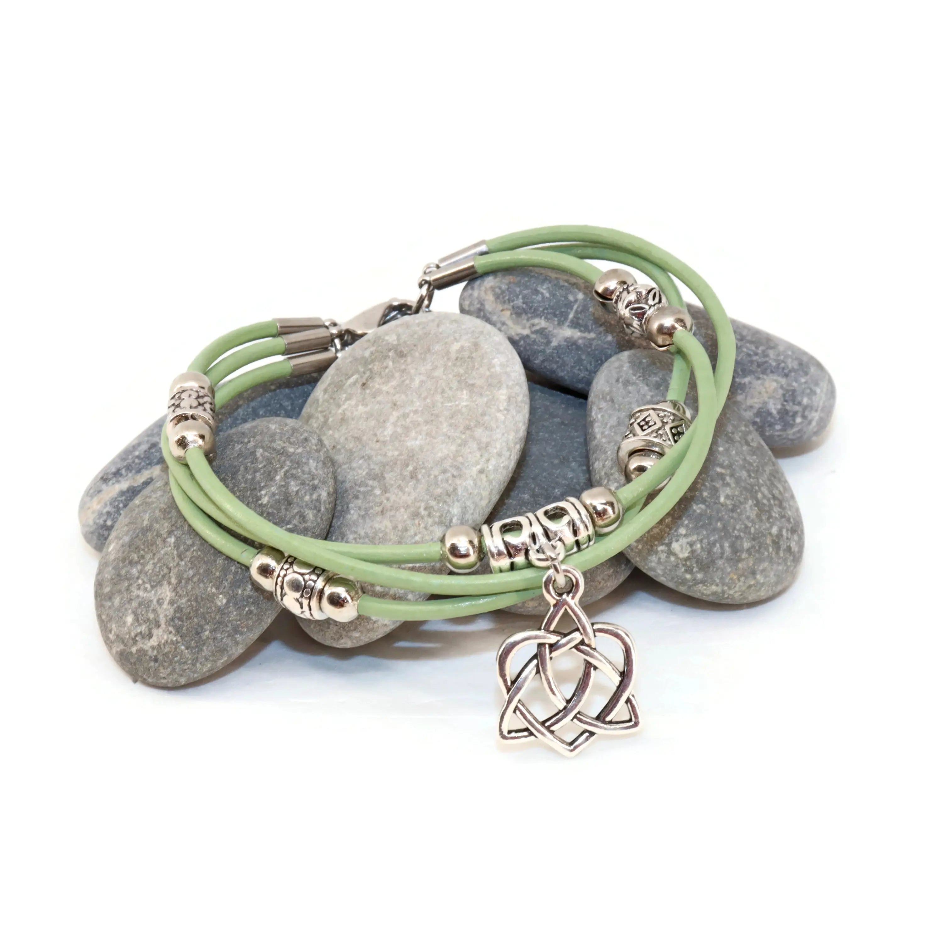 Green bracelet with a heart charm on stones