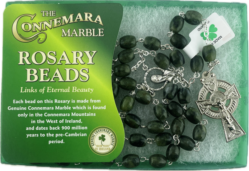 Rosary beads with Connemara Marble packaging on a green background