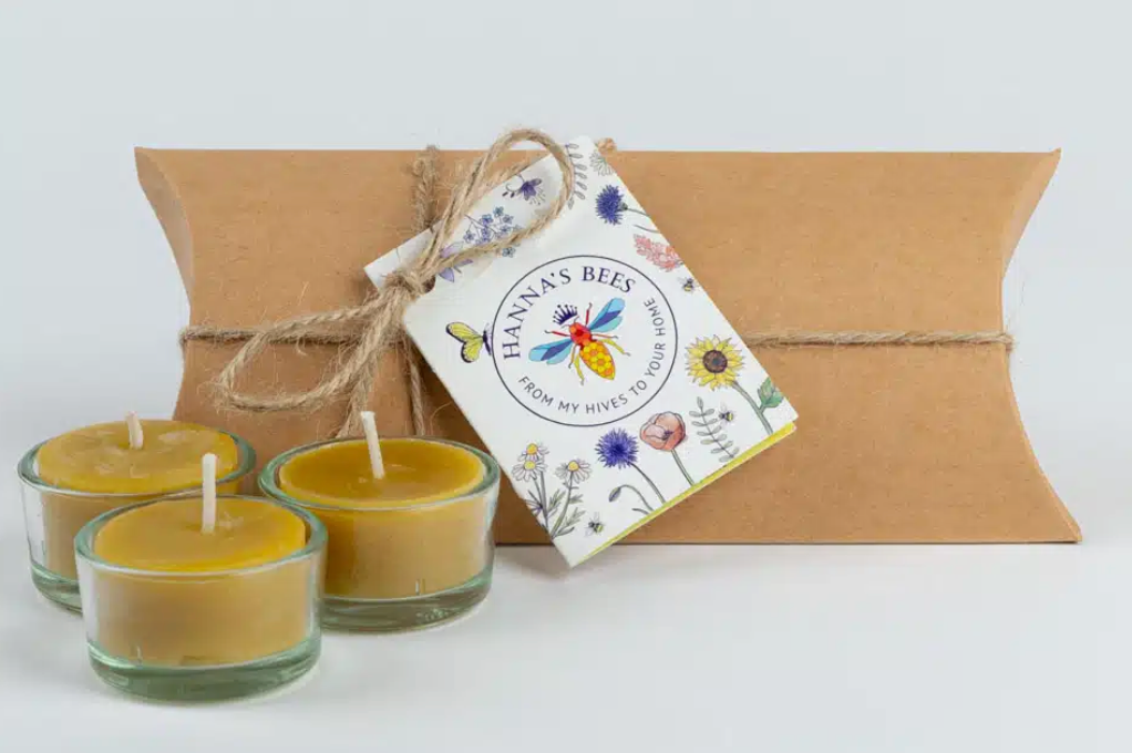 Three small glass candles with a decorative tag on a white background