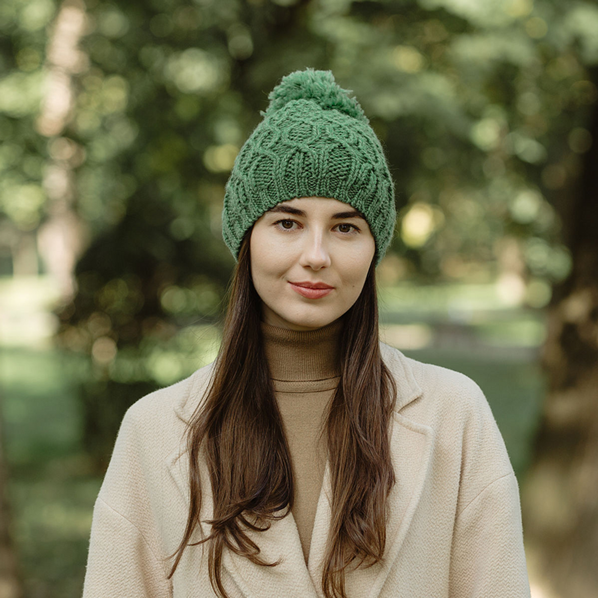Woman wearing a green knitted beanie in a park setting