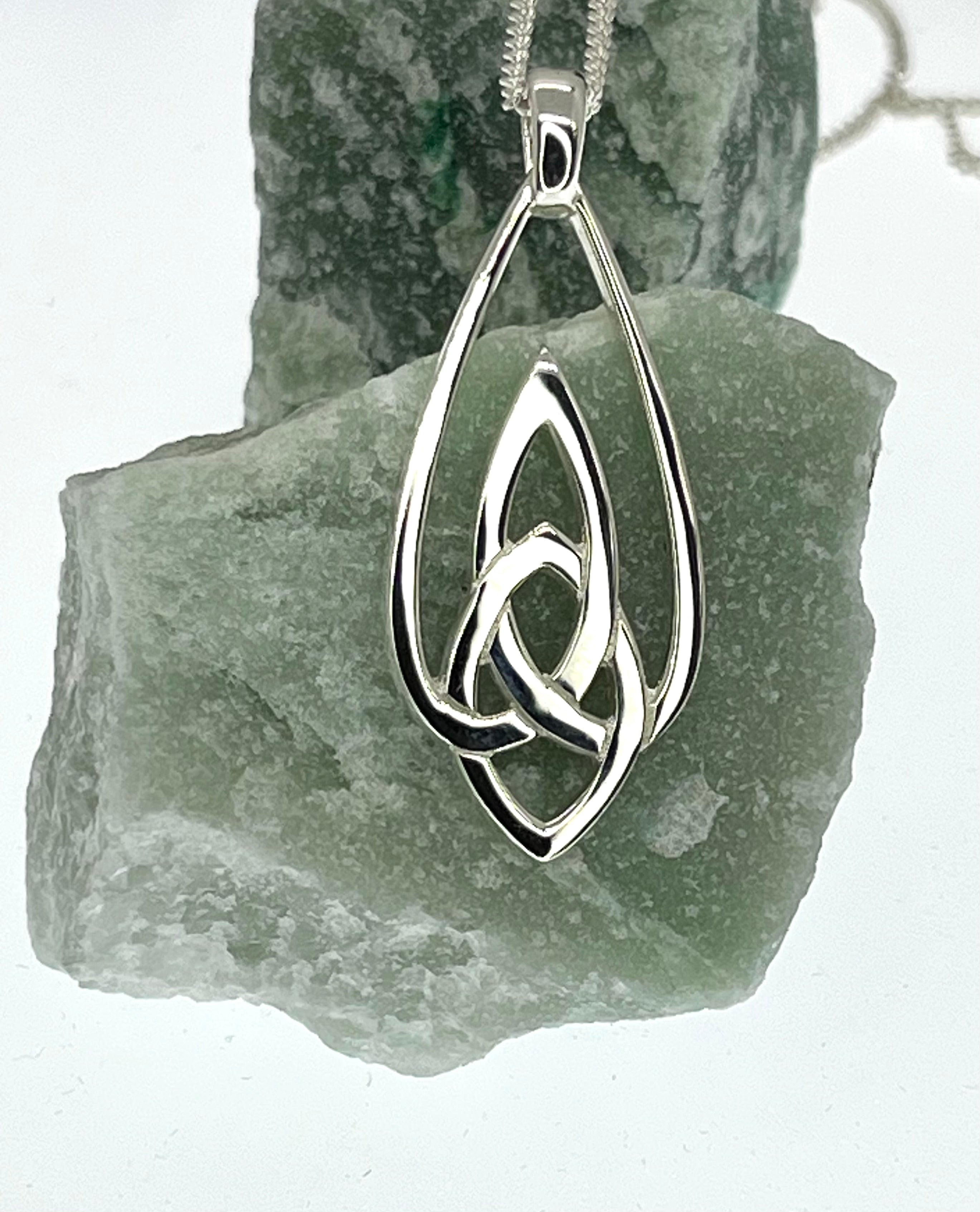 Silver Celtic knot pendant on a stone background