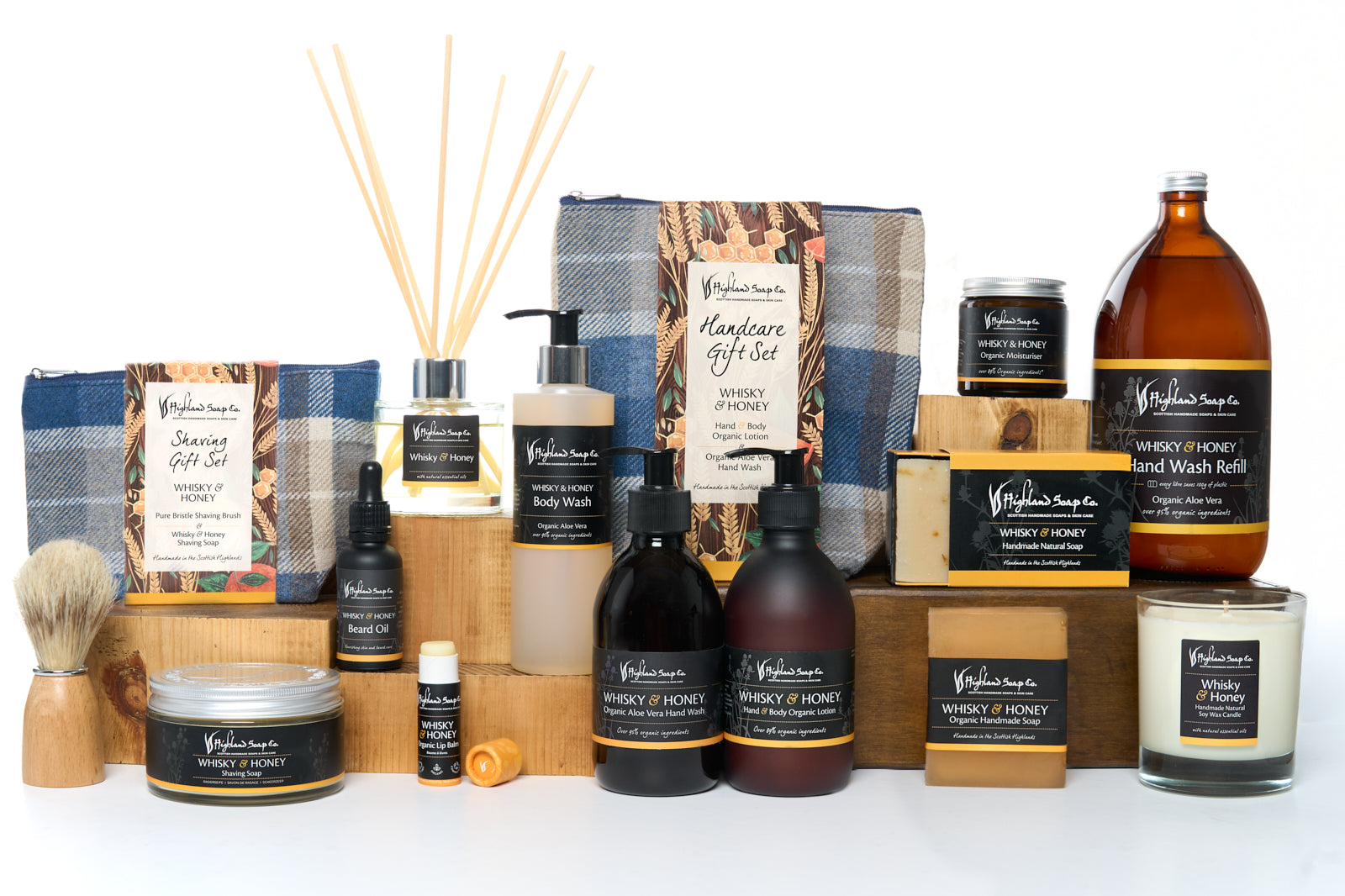 Collection of products including soap & lotion bottles, candles, and a brush on a white background.