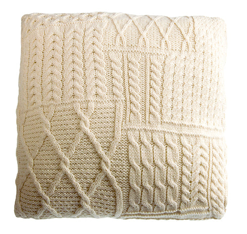 Knitted blanket with cable pattern on a white background