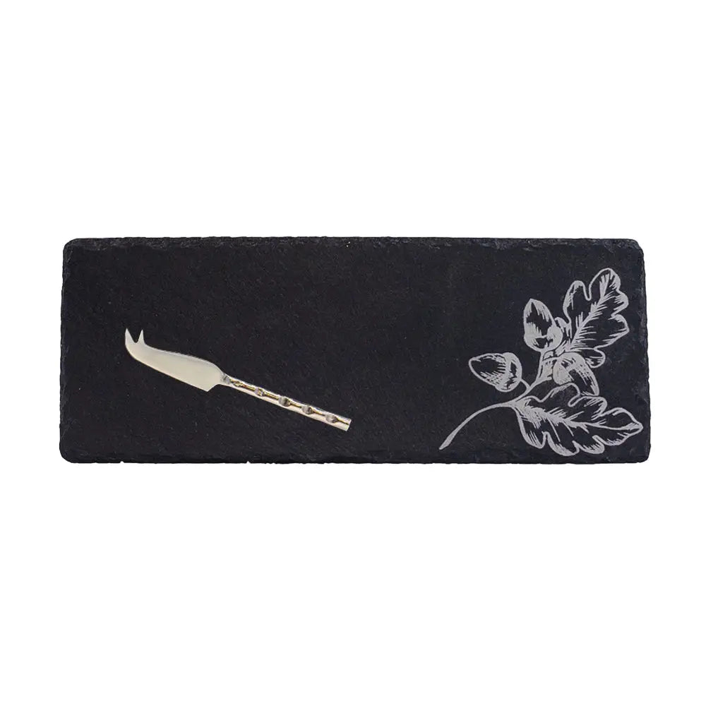 Black slate cheese board with floral design and knife on a white background