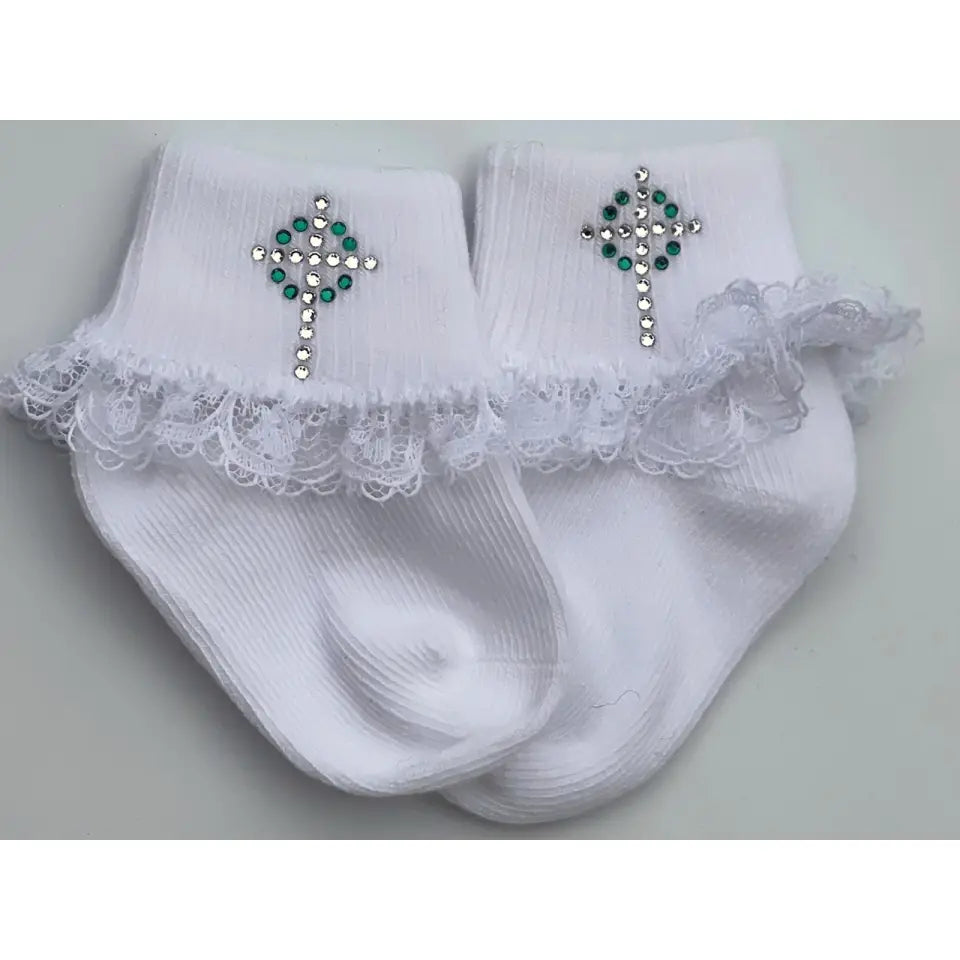 White socks with lace trim and decorative crosses on a light gray background