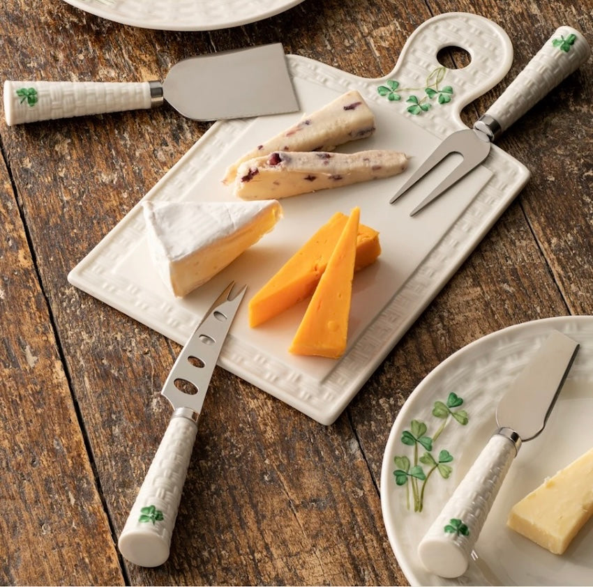 Cheese platter set with cheese and utensils on a wooden surface