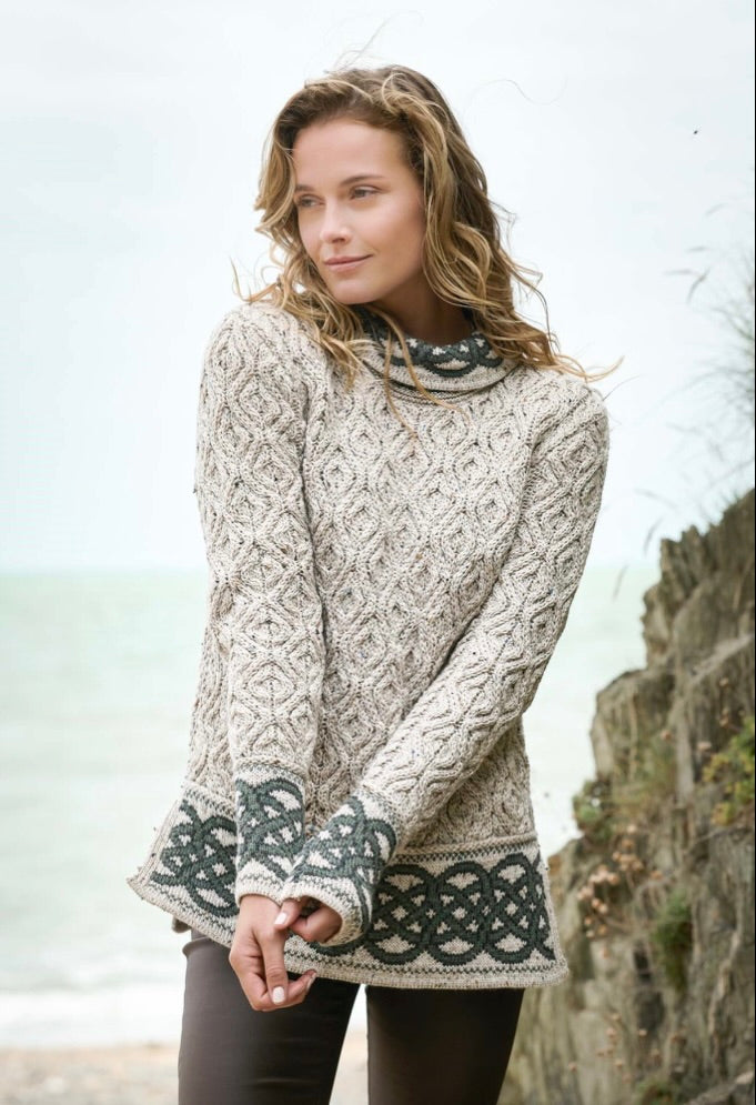 Woman wearing a patterned sweater standing outdoors with a blurred background