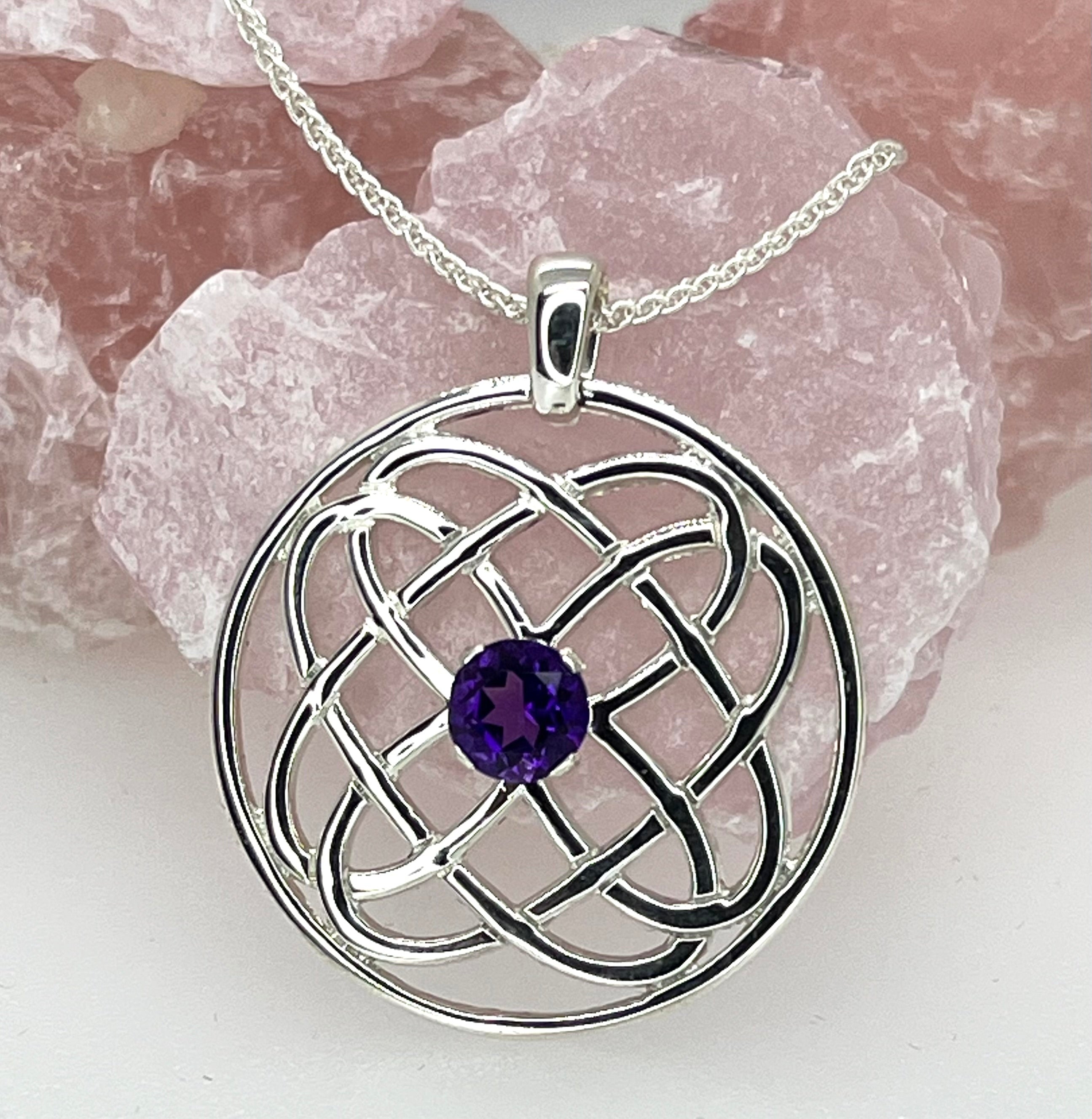 Silver Celtic knot pendant with an amethyst stone on a white background