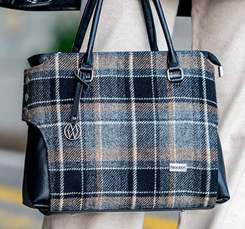 Plaid patterned handbag with black handles and trim, featuring a brand logo.