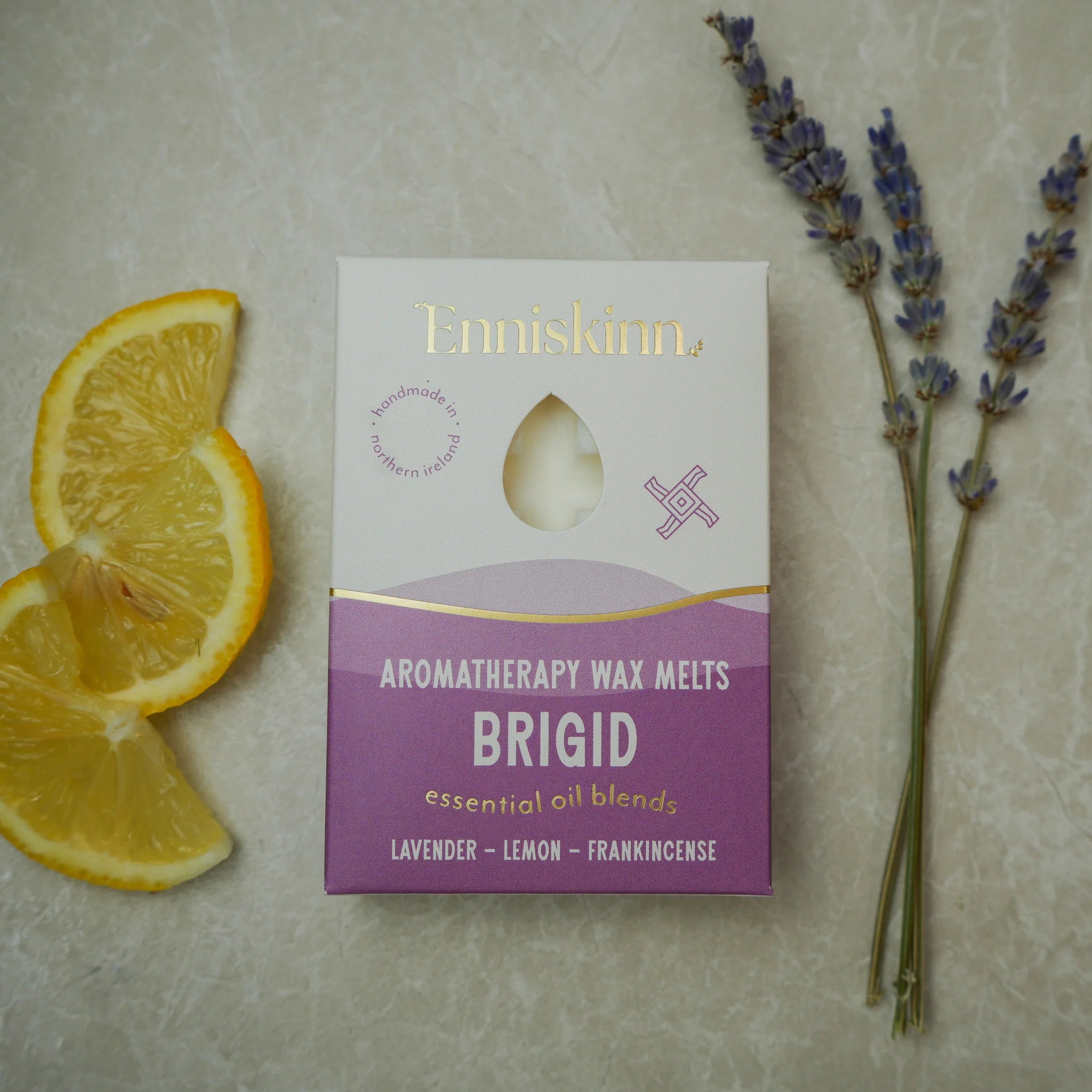 Enniskinn aromatherapy wax melts packaging with lemon slices and lavender on a neutral background