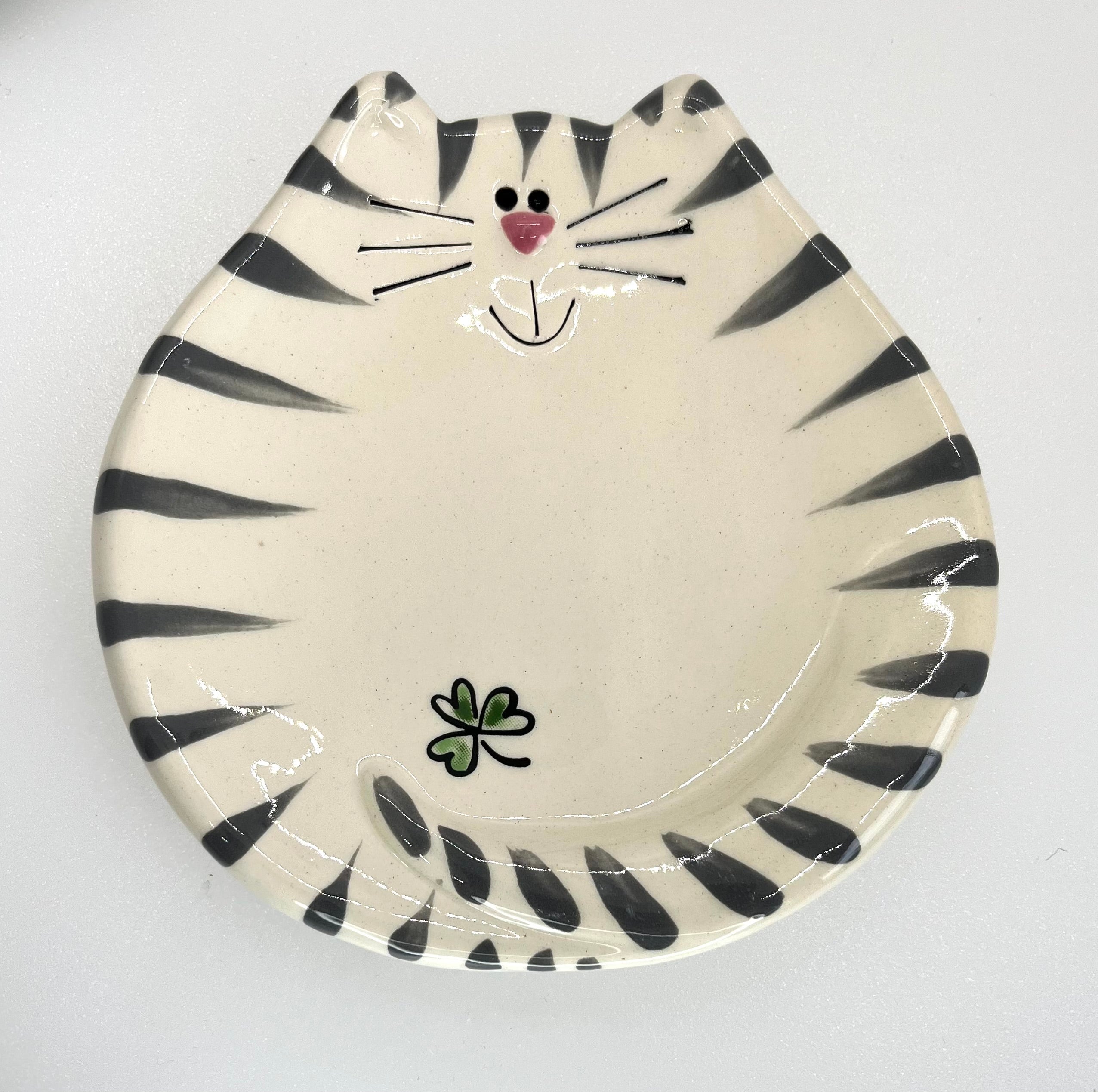 Ceramic plate designed like a cat face with black stripes on a white background