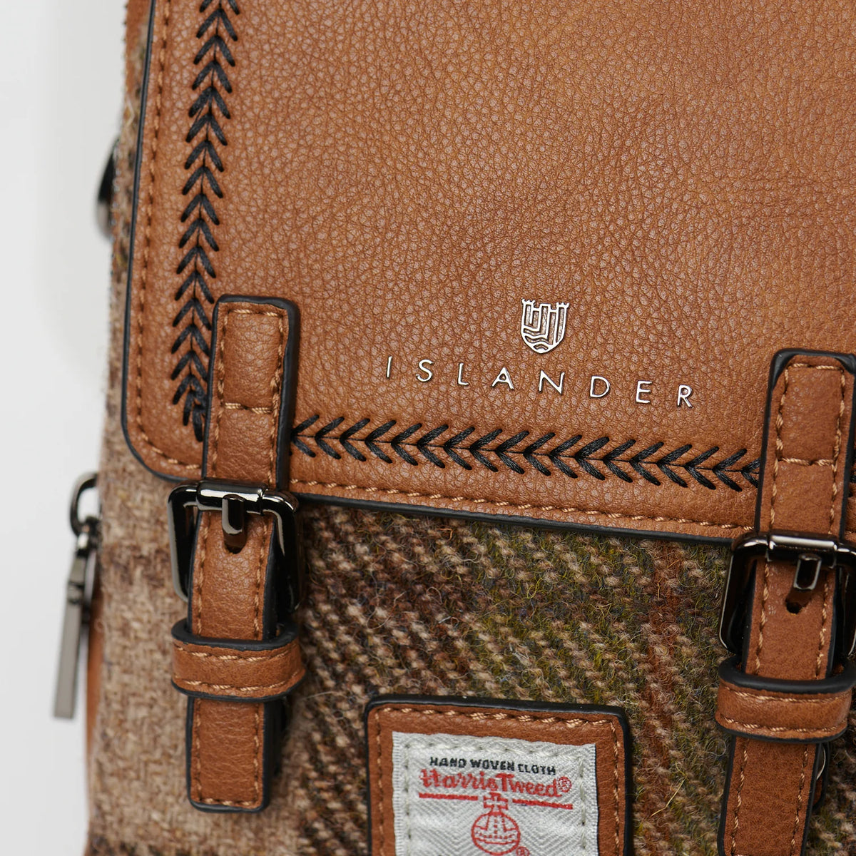 Close-up of a brown leather bag with 'Islander' branding and Harris Tweed label.