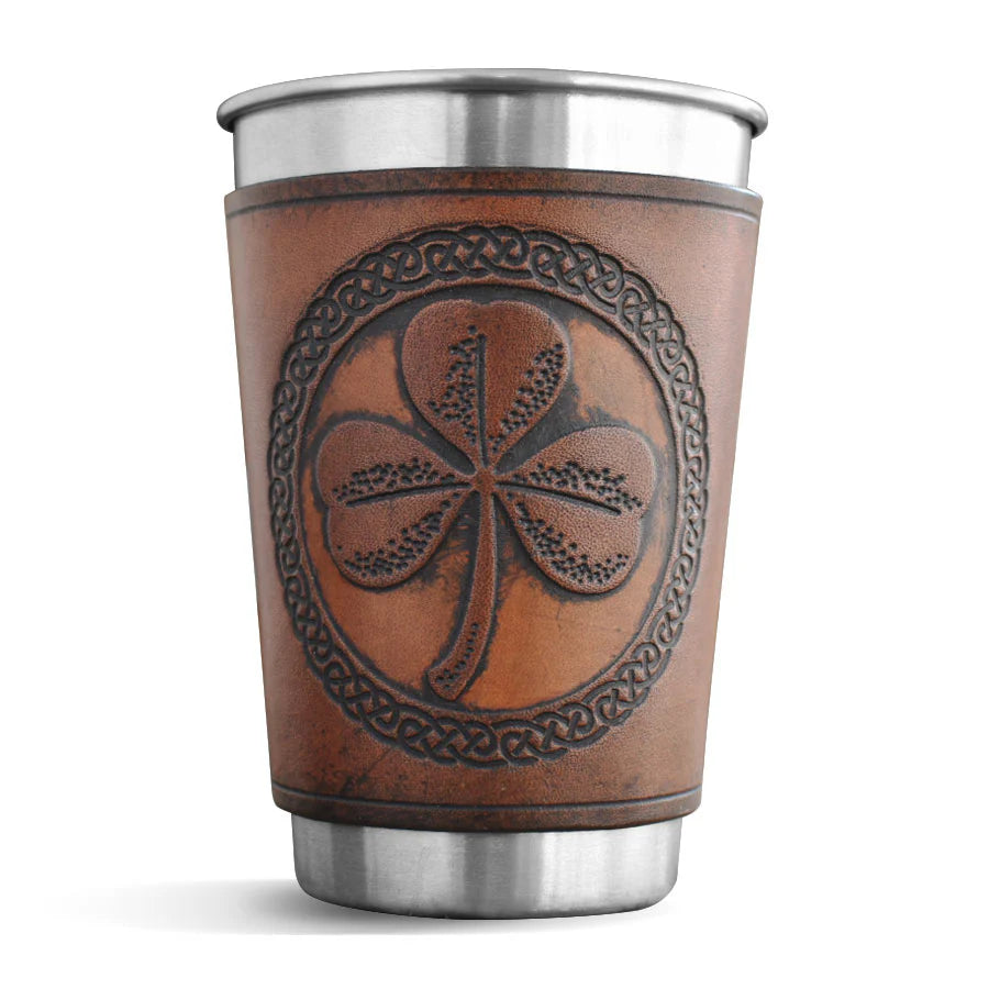 Stainless steel cup with a leather sleeve featuring a shamrock design on a white background