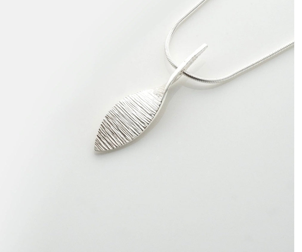 Silver leaf-shaped pendant on a white background