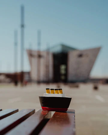 Small model ship on a wooden surface with a blurred background