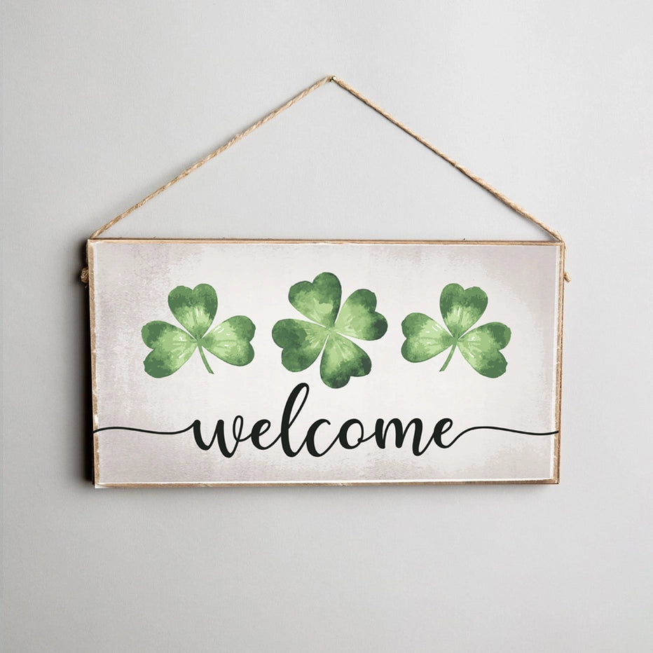 Decorative sign with green shamrocks and 'welcome' text on a light background