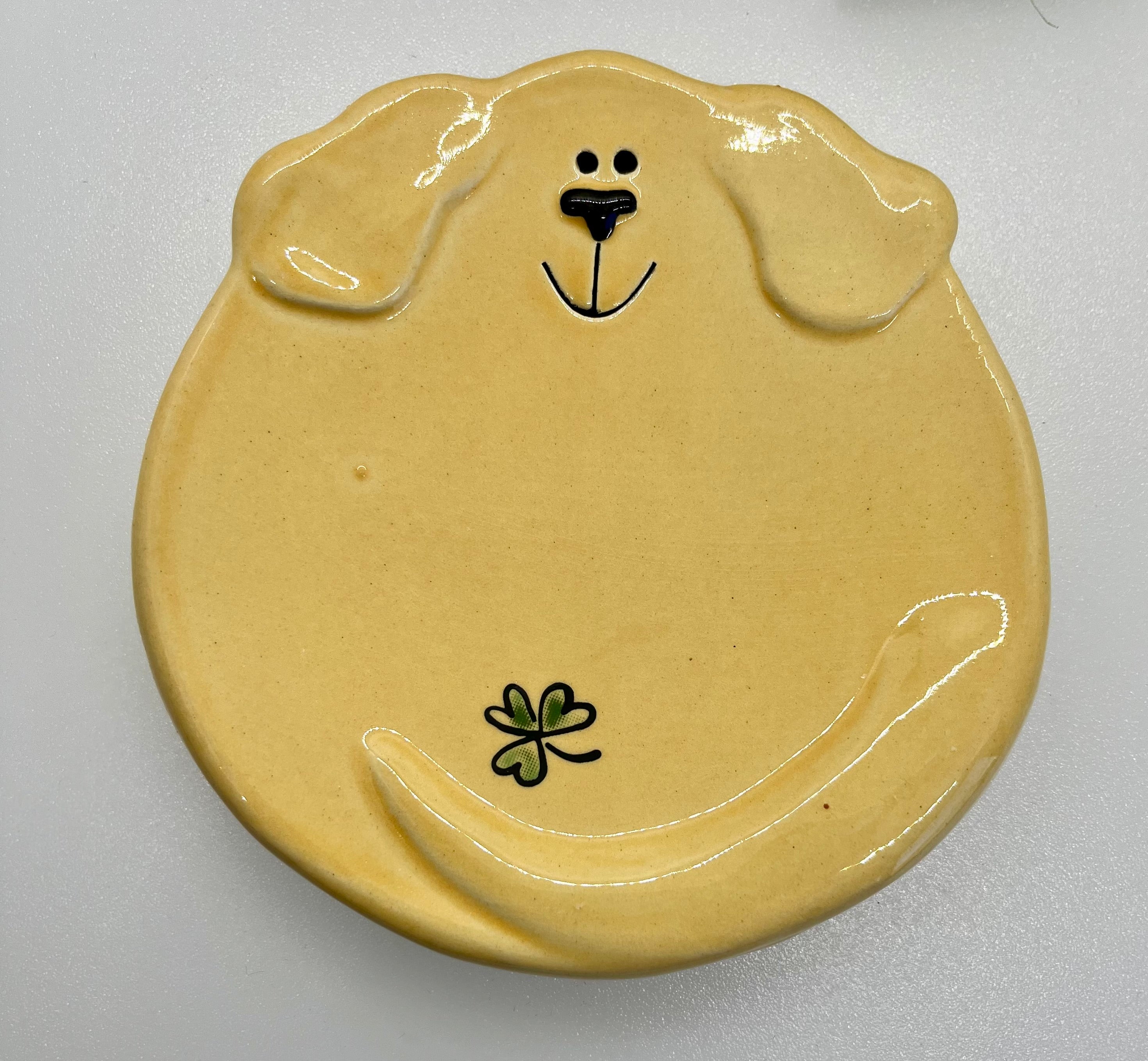 Dog-shaped ceramic plate with a smiling face on a white background