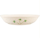 White pasta bowl with green shamrock floral design on a white background