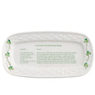White ceramic platter with clover designs and text on a white background