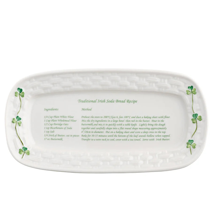 White ceramic platter with clover designs and text on a white background