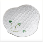 White ceramic plate with wicker pattern and clover design on a white background
