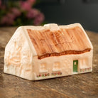 Small house-shaped object on a wooden surface with a blurred background