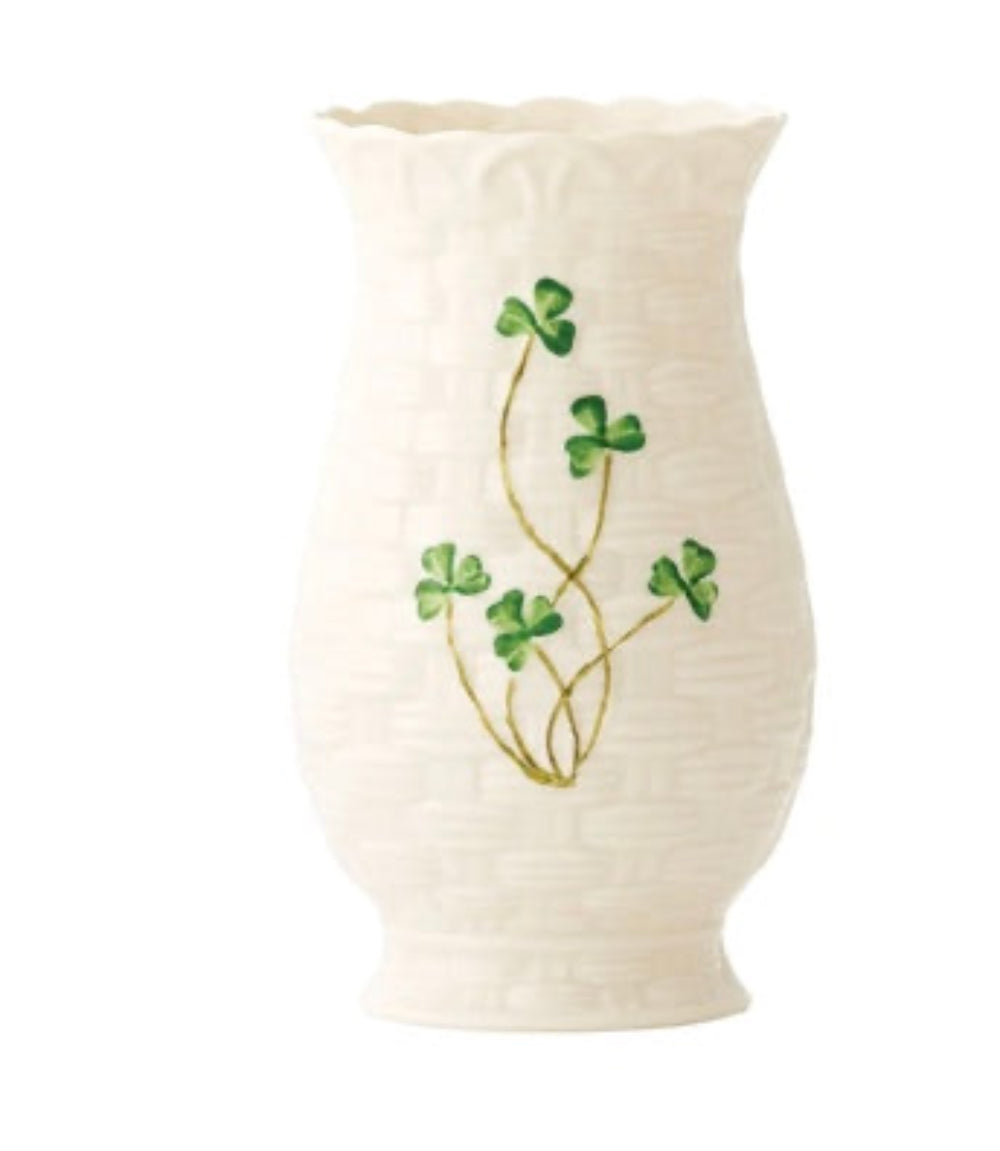 White vase with green clover leaf design on a white background