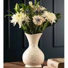 White vase with floral arrangement on a dark background