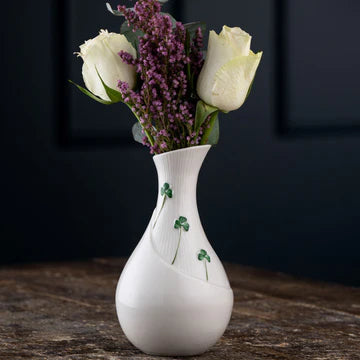 White vase with floral arrangement on a dark background