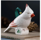 White cardinal ornament with red accents on a dark background