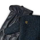 Pair of black leather gloves with a textured blue fabric surface featuring a logo.