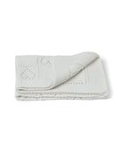 Folded textured blanket on a white background