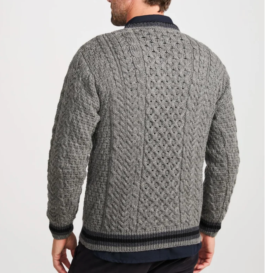 A man wearing a gray cable-knit sweater with dark navy ribbed trim, shown from the back against a plain light gray studio background.