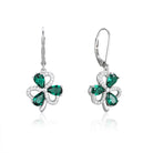Shiny silver earrings with green gemstones on a white background