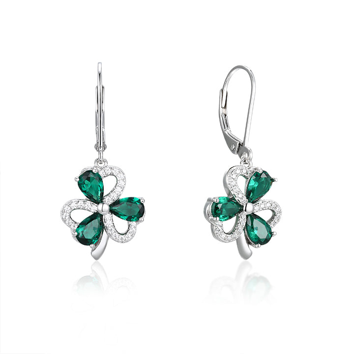 Shiny silver earrings with green gemstones on a white background