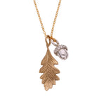 Necklace with bronze leaf and silver pewter acorn pendant on a white background