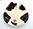 Ceramic plate shaped like a black and white cat on a white background