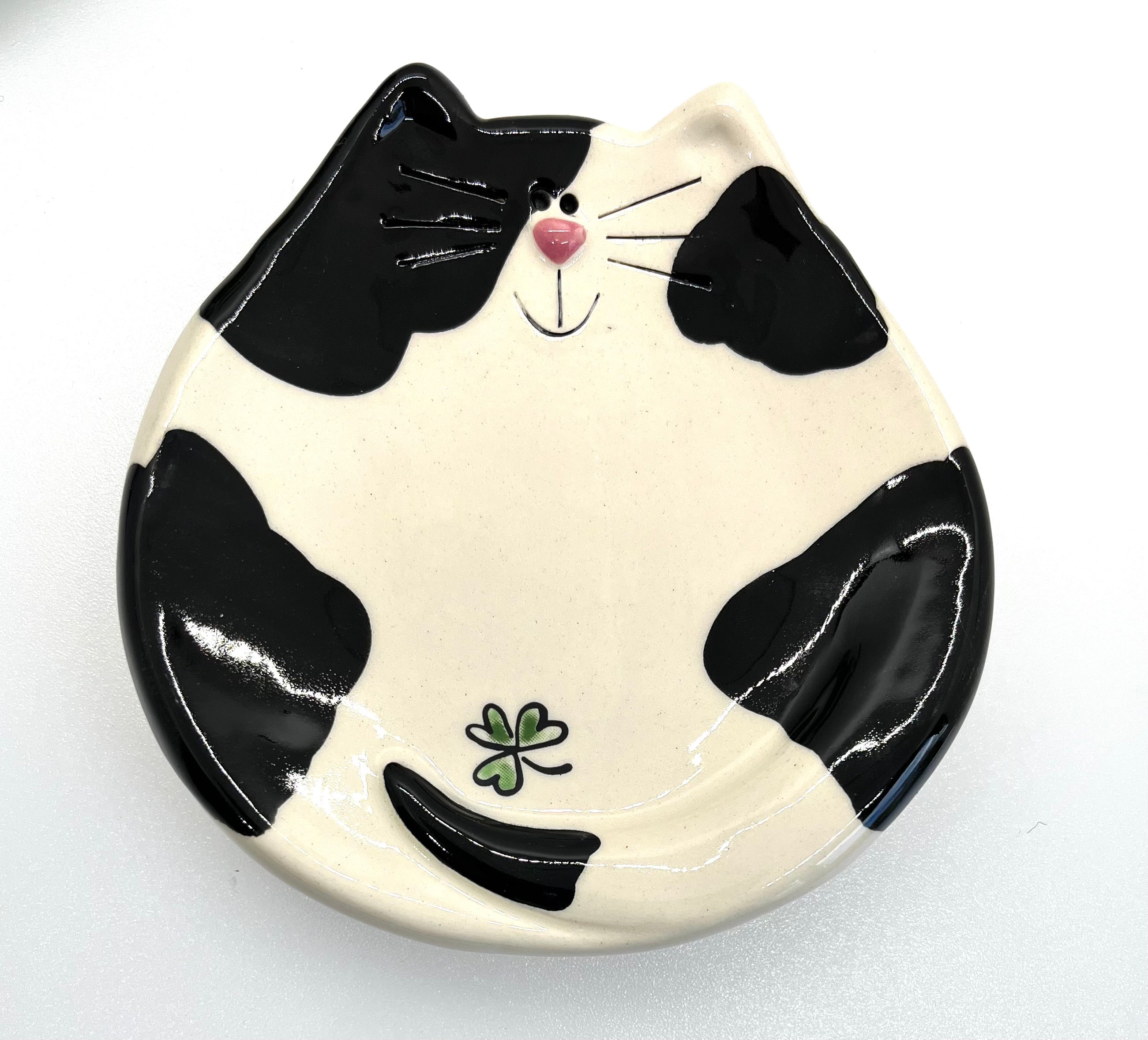 Ceramic plate shaped like a black and white cat on a white background