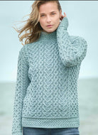 Woman wearing a textured green sweater by a body of water