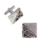 Pair of silver cufflinks with intricate design on a white background