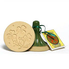 Cookie stamp with clover design and green handle on a white background