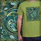 Person wearing a green t-shirt with a Celtic design in front of a colorful tapestry.