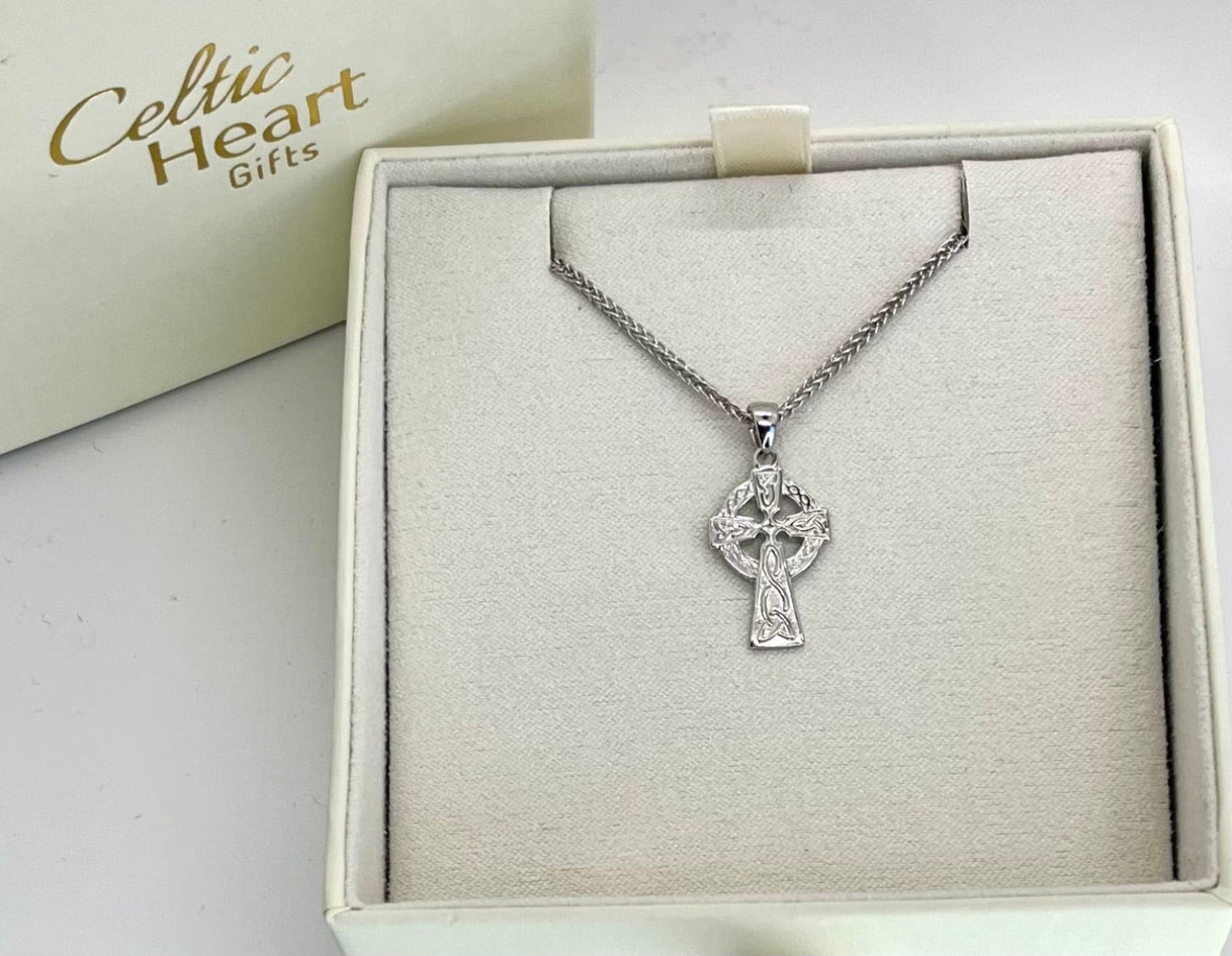 Silver cross pendant necklace in a box with 'Celtic Heart Gifts' branding.