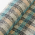 Close-up of plaid fabric with blue, gray, and beige colors.